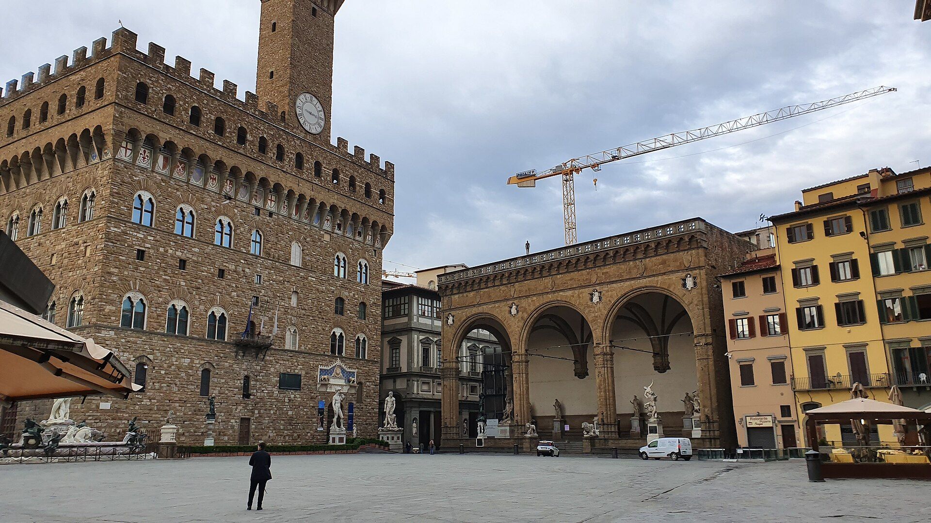 Palazzo Vecchio and the arches of the Loggia dei Lanzi on a quiet, cloudy day.
