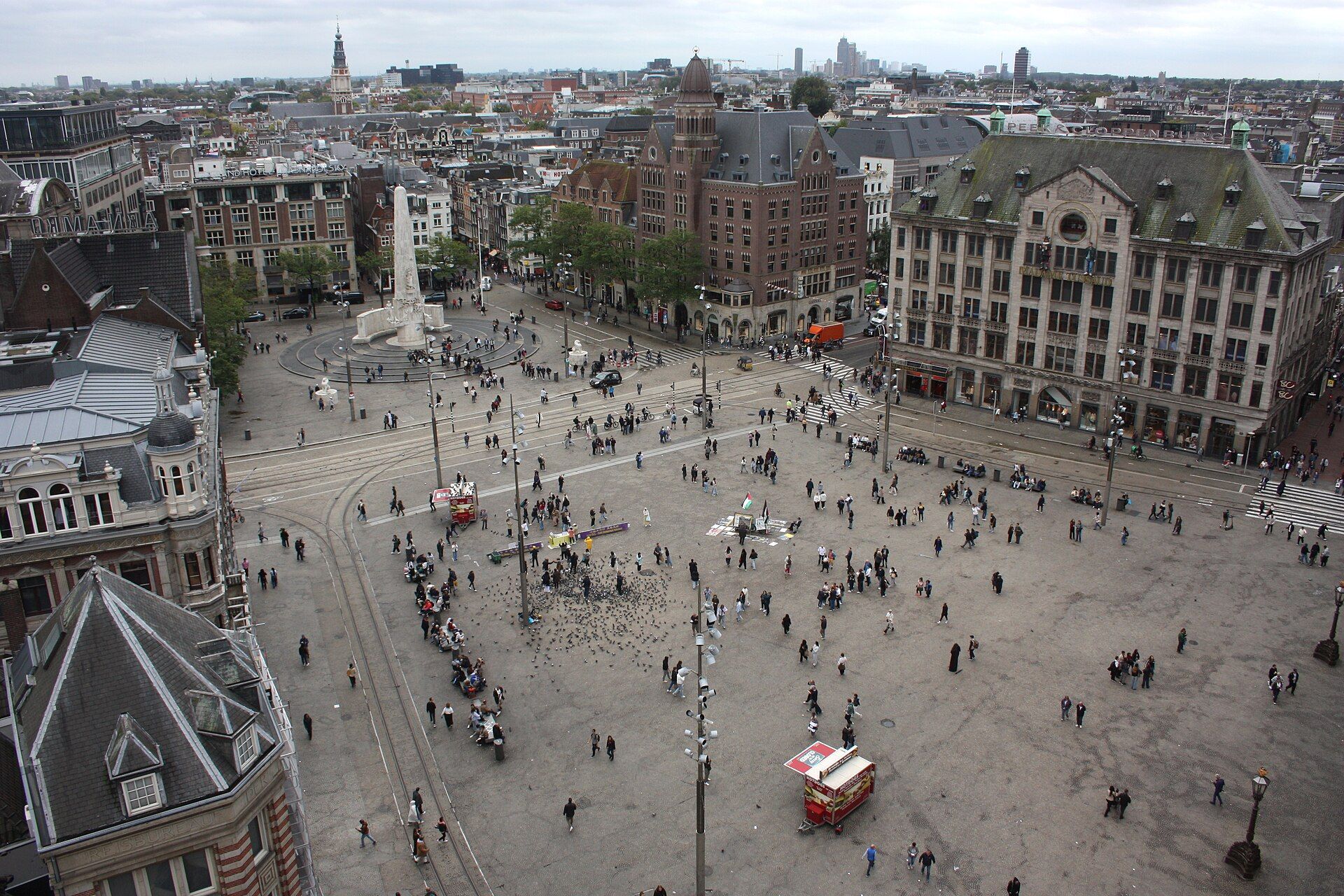 Dam Square seen from the roof of the Nieuwe Kerk, with the National Monument and people crossing the square.